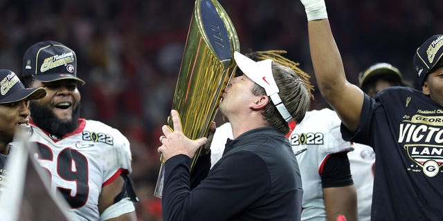 Georgia head coach Kirby Smart celebrates with the national championship trophy after the Georgia Bulldogs defeated the Alabama Crimson Tide 33-18 in the 2022 CFP national championship game at Lucas Oil Stadium Jan. 10, 2022, in Indianapolis.