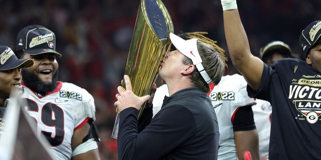 Georgia head coach Kirby Smart celebrates with the national championship trophy after the Georgia Bulldogs defeated the Alabama Crimson Tide 33-18 in the 2022 CFP national championship game at Lucas Oil Stadium Jan. 10, 2022, in Indianapolis.