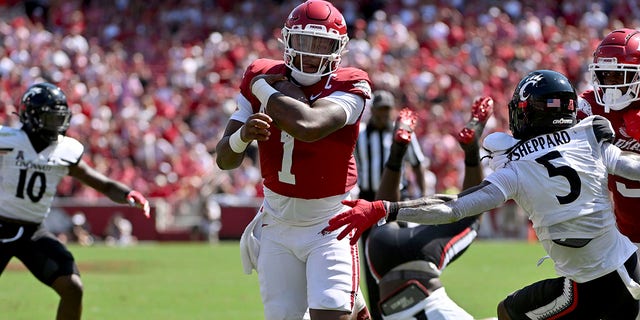 Arkansas quarterback KJ Jefferson (1) runs past Cincinnati defensive back J...