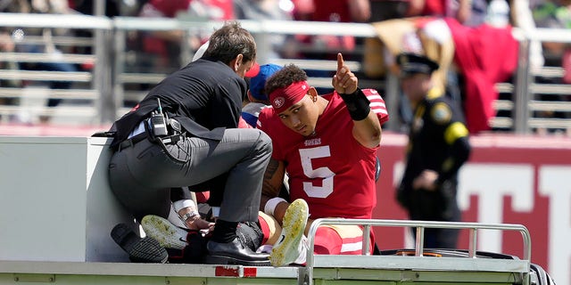 San Francisco 49ers quarterback Trey Lance gestures while being carted off the field during the first half against the Seattle Seahawks in Santa Clara, California, on Sept. 18, 2022.