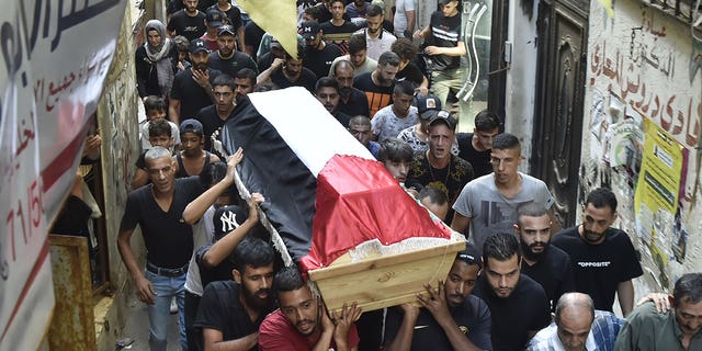 Pictured: People carrying a coffin of Palestinian Rawad Tareq Sayyed, who died from a sinking migrant boat off the coast of Syria, during a funeral in Beirut, Lebanon, on Sept. 24, 2022.