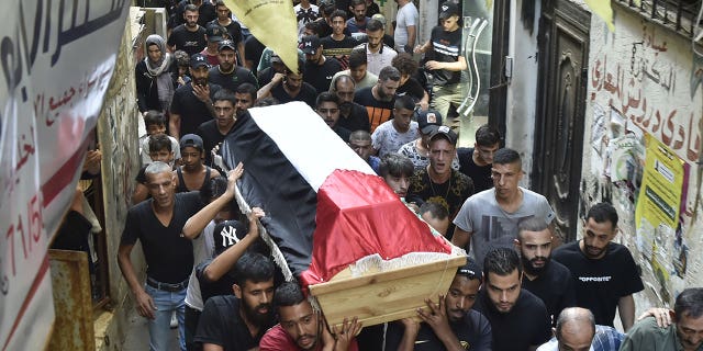 Pictured: People carrying a coffin of Palestinian Rawad Tareq Sayyed, who died from a sinking migrant boat off the coast of Syria, during a funeral in Beirut, Lebanon, on Sept. 24, 2022.