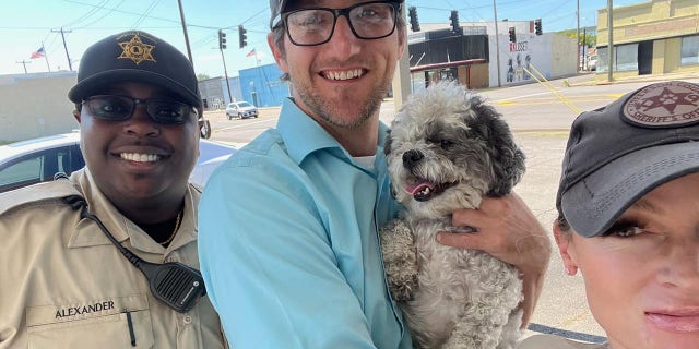 Cullman County and Jefferson County officers snap a selfie with Phillip Lewis after rescuing his dog, Little Dude.