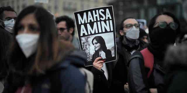 Protesters in Berlin, Germany, protest the death of Mahsa Amini on Sept. 28, 2022, after she died in police custody in Iran for wearing her hijab too loosely.