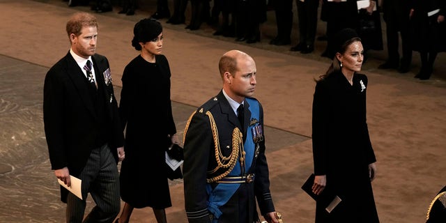 Prince Harry, Duke of Sussex and Meghan, Duchess of Sussex, Prince William, Prince of Wales and Catherine, Princess of Wales walk behind the coffin at the Palace of Westminster after the procession for the Lying-in State of Queen Elizabeth II on September 14, 2022, in London, England. 