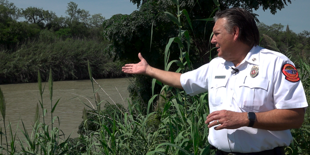 Chief Manuel Mello points to a spot in the Rio Grande where the Eagle Pass Fire Department often recovers drowning victims' bodies. 