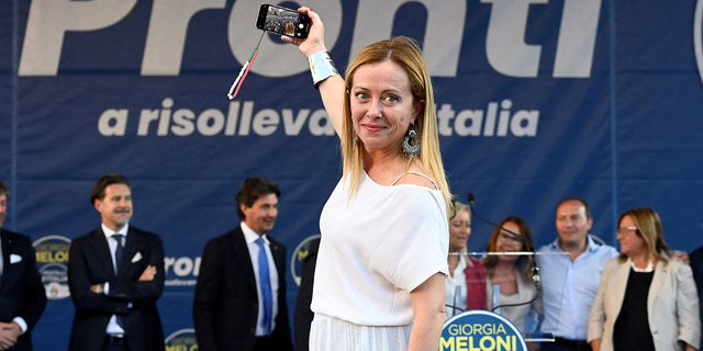 Giorgia Meloni, leader of the Brothers of Italy party, takes a selfie during a rally in Duomo square ahead of the Sept. 25 snap election, in Milan, Italy, September 11, 2022.
