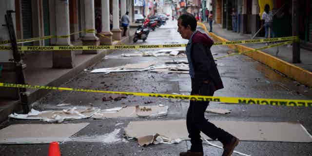 Man walks down a street in Coalcoman, Mexico, on Sept. 20, 2022, after it was damaged by an earthquake the day before.