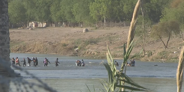 Migrants cross the Rio Grande at Eagle Pass, Texas.