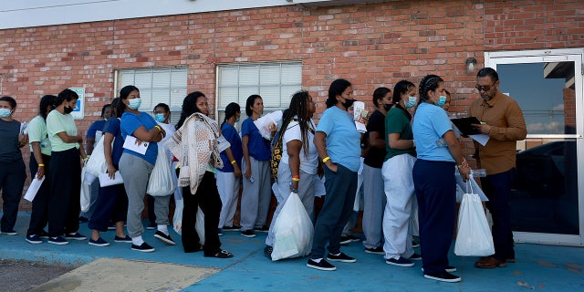 Migrants who recently arrived in the U.S. from Venezuela after crossing from Mexico wait to be assigned a hotel room provided by the El Paso Office of Emergency Management in Texas.