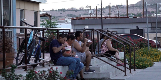 Migrants eat dinner outside the Rescue Mission of El Paso Wednesday, Sept. 21, 2022.