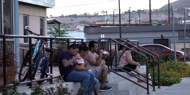 Migrants eat dinner outside the Rescue Mission of El Paso Wednesday, Sept. 21, 2022.