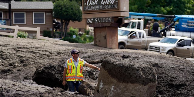 Paul Burgess of the California Geological Survey examines the damage made by a mudslide in Oak Glen, California, on Sept. 13, 2022.