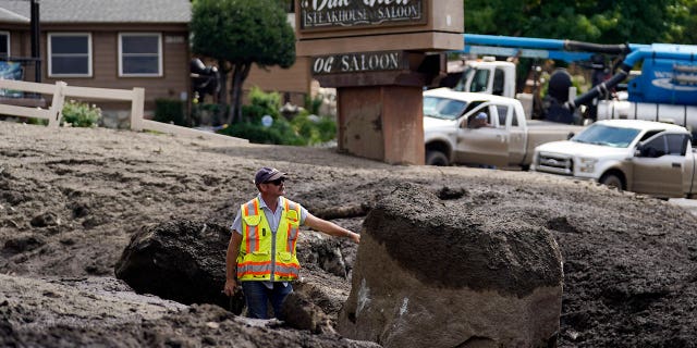 Paul Burgess of the California Geological Survey examines the damage made by a mudslide in Oak Glen, California, on Sept. 13, 2022.