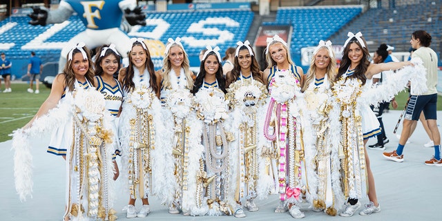 A group of seniors at Frisco High School in Frisco, Texas, show off their homecoming mums at the homecoming football game in their town. 