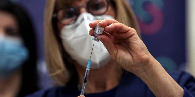 A nurse prepares a fourth COVID vaccine as part of a trial in Israel, at Sheba Medical Center in Ramat Gan, Israel, on Dec. 27, 2021.