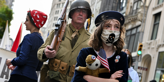 A girl from the Long Island Historical Association dresses as a child during an American Revolution reenactment at the 102nd annual Veterans Day parade on November 11, 2021, in New York City.