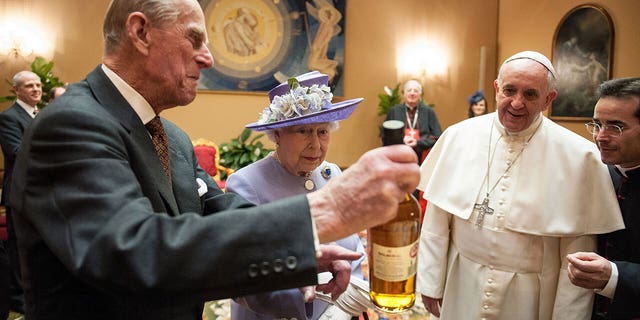 Queen Elizabeth II and Prince Philip, Duke of Edinburgh exchange gifts with Pope Francis at Paul VI Hall in Vatican City on April 3, 2014.