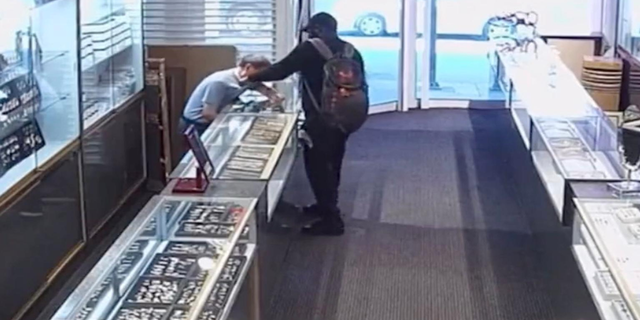 Video shows the attacker grabbing the store owner's throat and whipping him in the head with his pistol.