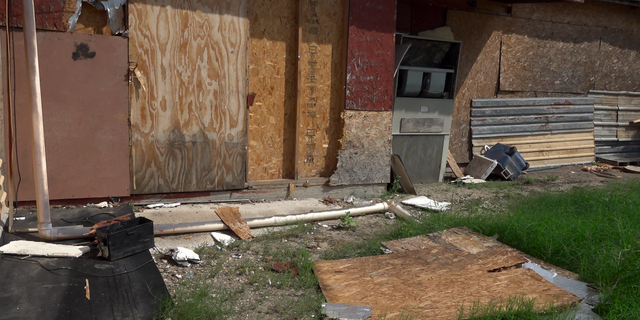 Plywood ripped from the side of the Wagon Wheel lays next to a recently boarded off section of the former business. 