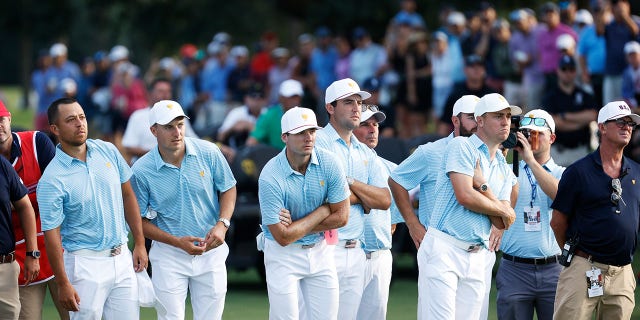 Xander Schauffele, Jordan Spieth, Sam Burns, Scottie Scheffler, Assistant Captain Fred Couples, Cameron Young and Justin Thomas of the United States Team watch as Max Homa and Tony Finau of the United States Team play the 18th green during the Thursday foursome matches on day one of the 2022 Presidents Cup at Quail Hollow Country Club on September 22, 2022 in Charlotte, North Carolina.