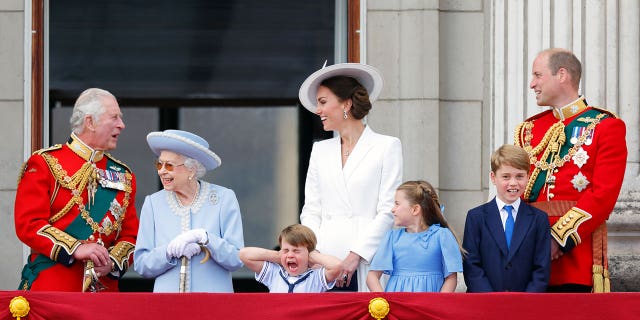 (L-R) Then-Prince Charles stands on the balcony of Buckingham Palace with Queen Elizabeth II, Prince Louis, Kate Middleton, Princess Charlotte, Prince George and Prince William in June during her Platinum Jubilee celebration. 