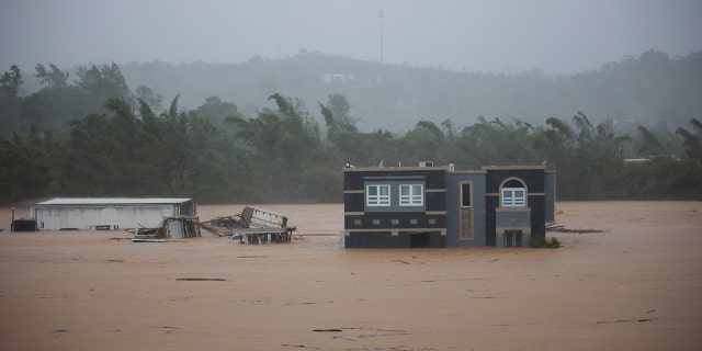 Hurricane Fiona submerges a home in floodwaters in Cayey, Puerto Rico, Sunday, Sept.  18, 2022. According to authorities three people were inside the home and were reported to have been rescued. 