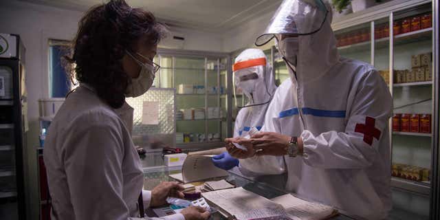 Customs records indicate that North Korea has imported shipments of unspecified COVID vaccines, suggesting the country may begin vaccinating their citizens. Pictured: North Korean health officials in Pyongyang, North Korea, assist a woman at a pharmacy on May 27, 2022.