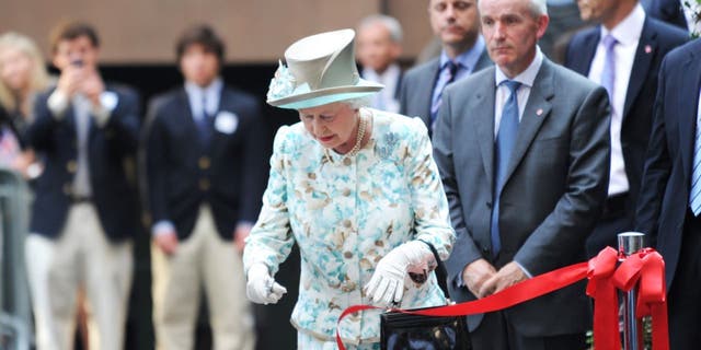 La reine Elizabeth II coupe un ruban lors de l'ouverture du British Garden à Hanover Square le 6 juillet 2010, à New York, en mémoire des Britanniques décédés au World Trade Center le 6 septembre 2010.  11, 2001. 