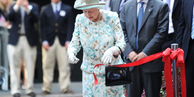 La reine Elizabeth II coupe un ruban lors de l'ouverture du British Garden à Hanover Square le 6 juillet 2010, à New York, en mémoire des Britanniques décédés au World Trade Center le 6 septembre 2010. 11, 2001.