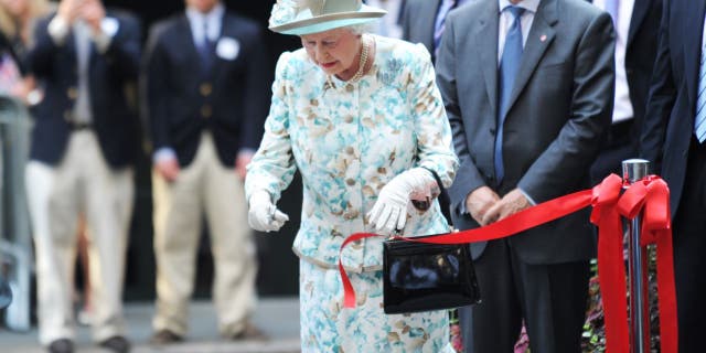 La reine Elizabeth II coupe un ruban lors de l'ouverture du British Garden à Hanover Square le 6 juillet 2010, à New York, en mémoire des Britanniques décédés au World Trade Center le 6 septembre 2010.  11, 2001. 