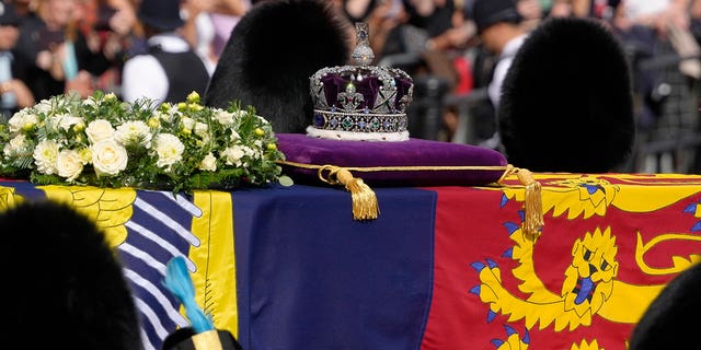 Grenadier Guards flank the coffin of Queen Elizabeth II during a procession from Buckingham Palace to Westminster Hall. The queen is lying in state in Westminster Hall before her funeral on Monday, Sept. 19. 