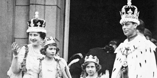 The crowned King George VI and Queen Elizabeth with Princess Elizabeth and Princess Margaret Rose, acknowledging the cheers of the crowd from the balcony of Buckingham Palace on their return from Westminster Abbey.