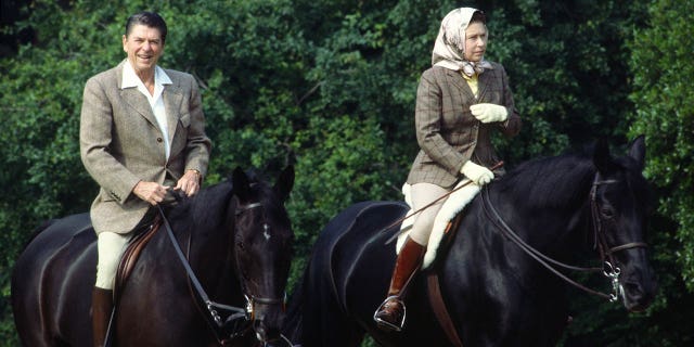 Queen Elizabeth Il rides her horse "Burmese" in Windsor Great Park during a state visit from President Reagan, who is riding "Centennial."