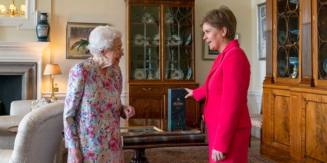 Britain's Queen Elizabeth II, left, greets Scotland's First Minister and leader of the Scottish National Party Nicola Sturgeon.