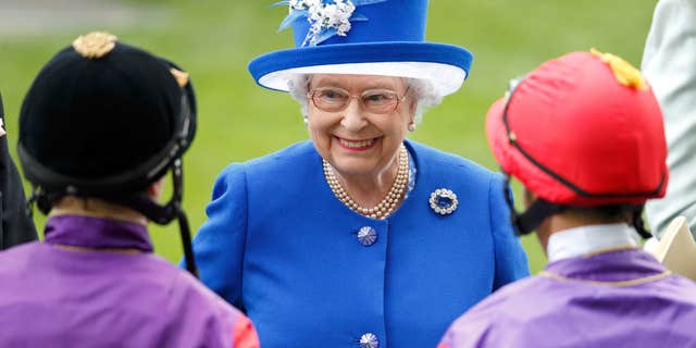 Queen Elizibeth meets with horse jockeys Jamie Spencer and Sean Levey before racing her horses "Touchline" and "Pack Together" at Ascot Racecourse on June 17, 2015, in Ascot, England.
