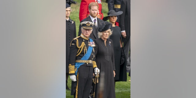 O rei Charles III, Harry, o duque de Sussex, Camilla, a rainha consorte e Meghan, duquesa de Sussex, observam o caixão da rainha Elizabeth II chegar ao Wellington Arch após seu funeral de estado na Abadia de Westminster.