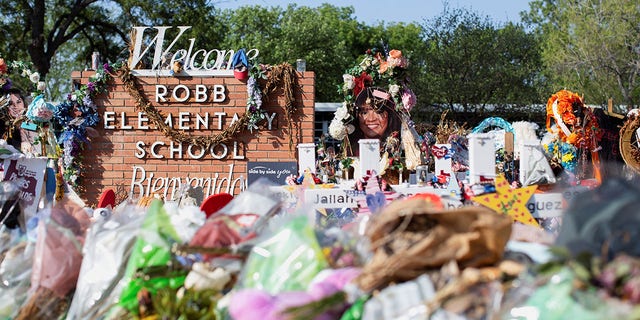 Privacy barriers and bike racks maintain a perimeter at a memorial outside Robb Elementary School July 13, 2022, after a video was released showing the May shooting inside the school in Uvalde, Texas.