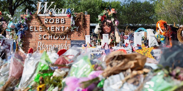 Privacy barriers and bike racks maintain a perimeter at a memorial outside Robb Elementary School in Uvalde, Texas in July.