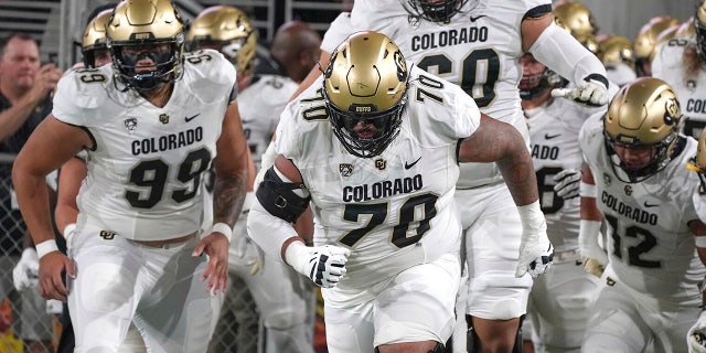 FILE - Colorado players lead by Casey Roddick (70) charge out onto the field before their NCAA college football game with Arizona State, Sept 25, 2021, in Tempe, Ariz. Colorado offensive lineman Casey Roddick nearly had his football career ended after a case of COVID-19 developed into a serious bout with myocarditis, an inflammation of the heart wall. These days, the left guard from California doesn't take even one snap for granted. That's why he relished his new role as team captain.