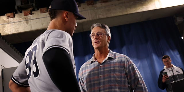 Aaron Judge #99 of the New York Yankees speaks to Roger Maris Jr. following the win against the Toronto Blue Jays at Rogers Centre on September 28, 2022, in Toronto, Ontario, Canada. 