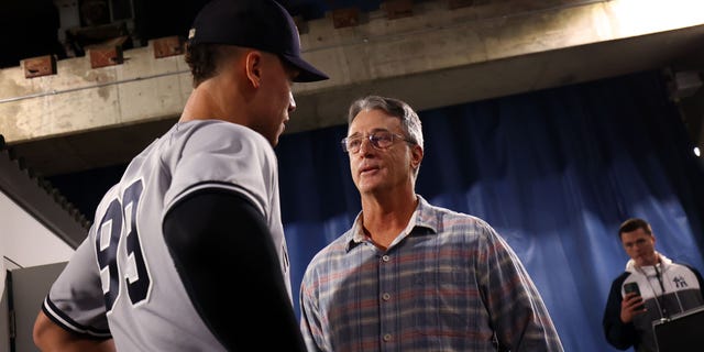Aaron Judge #99 of the New York Yankees speaks to Roger Maris Jr. following the win against the Toronto Blue Jays at Rogers Centre on September 28, 2022, in Toronto, Ontario, Canada.