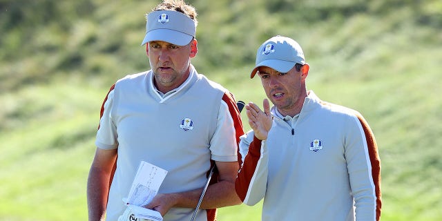 Ian Poulter of England, left, and Rory McIlroy of Northern Ireland line up a putt during the 43rd Ryder Cup at Whistling Straits in Kohler, Wisconsin, on Sept. 25, 2021.