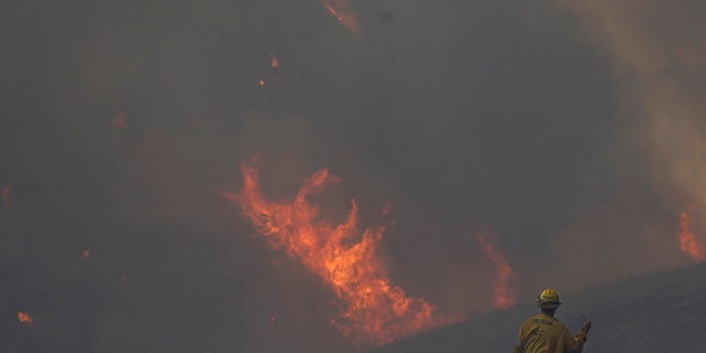 Firefighter Brad Goodfellow,  of the Los Angeles County Engine 80, watches the Route Fire as it burns a ridge Wednesday, Aug. 31, 2022, in Castaic, California.