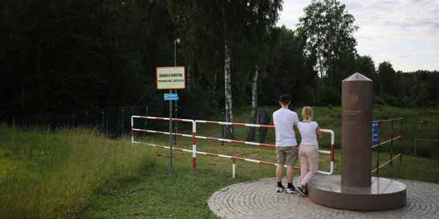 People are seen on the tri-point boarder of Poland, Lithuania and Russia on June 7, 2022, which has now been closed off to Russian's fleeing the military draft in their country.