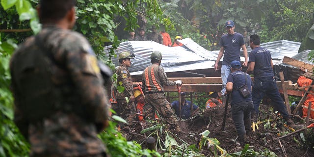 Two children died drowning when they were swept away in a rain-swollen gully in El Salvador. Pictured: Soldiers and rescuers try to recover the bodies of people who died after a landslide caused by heavy rain in Huizucar, El Salvador, on Sept. 22, 2022.