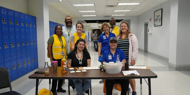 Volunteers pose at a Seminole County Public School prior to Hurricane Ian making landfall in Florida.