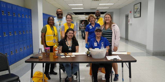 Volunteers wait for evacuees at a school-turned-shelter as Hurricane Ian hits Florida.