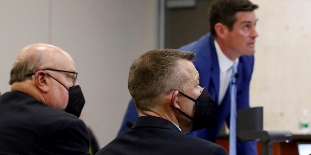 Prosecutor Chris Puervelle puts a slide on a projection screen as defense attorney Paul Sanger, left, and defendant Paul Flores look on in Monterey County Superior Court during the Kristin Smart murder trial. 