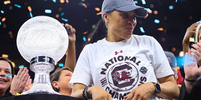 South Carolina Gamecocks head coach Dawn Staley receives the WBCA Coaches Trophy after defeating the UConn Huskies in the championship game of the NCAA Women's Basketball Tournament at the Target Center in Minneapolis, Minnesota on April 3, 2022 .